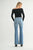 Woman wearing blue flared jeans and a black top on a white background