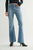 Person wearing light blue flared jeans on a plain background