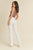 Woman wearing a brown top and white pants on a beige background